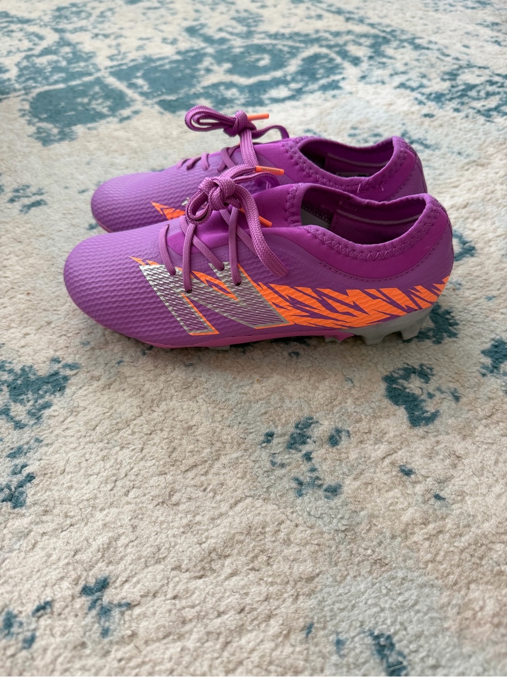 New Balance Purple Kids Soccer Cleats with Orange Accents